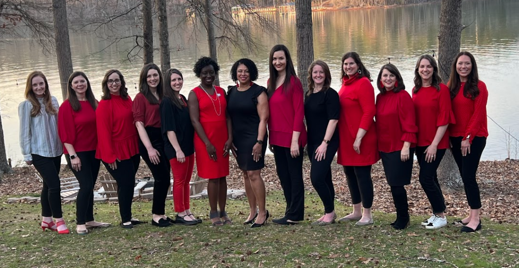Photo of the 2022-2023 Junior League of Greenville Board Members standing in front of a lake